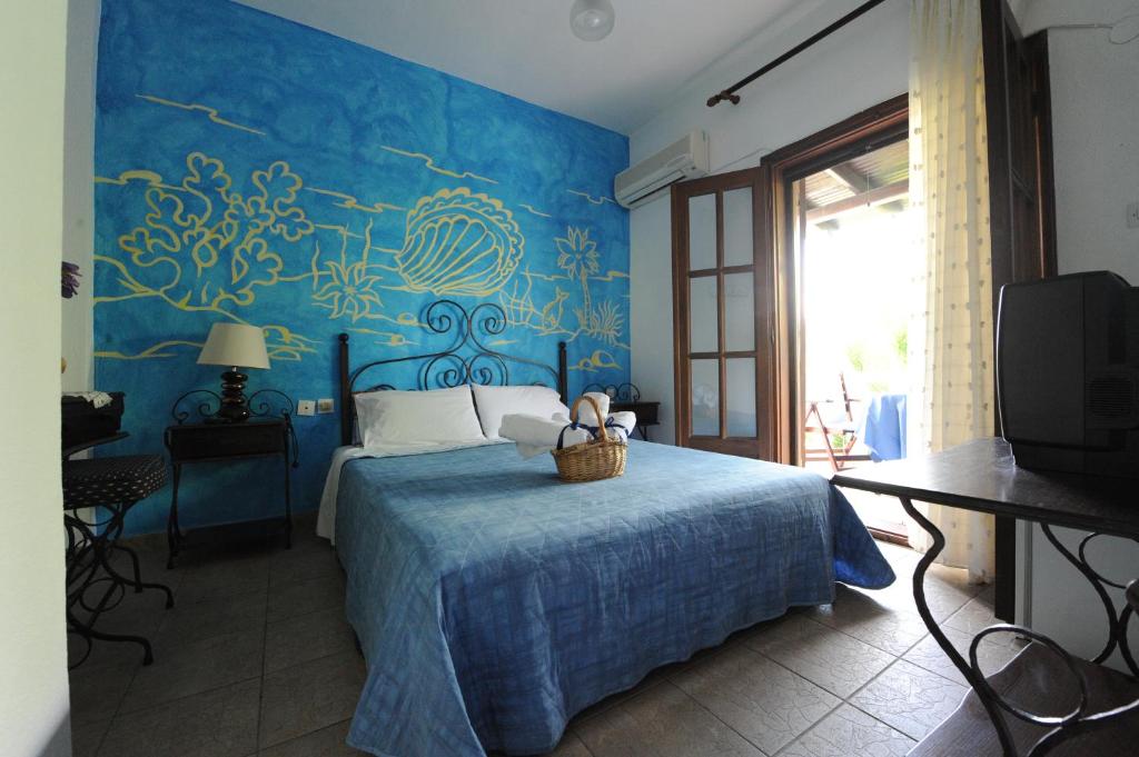a blue bedroom with a bed with a basket on it at Thalassa Hotel in Ammouliani