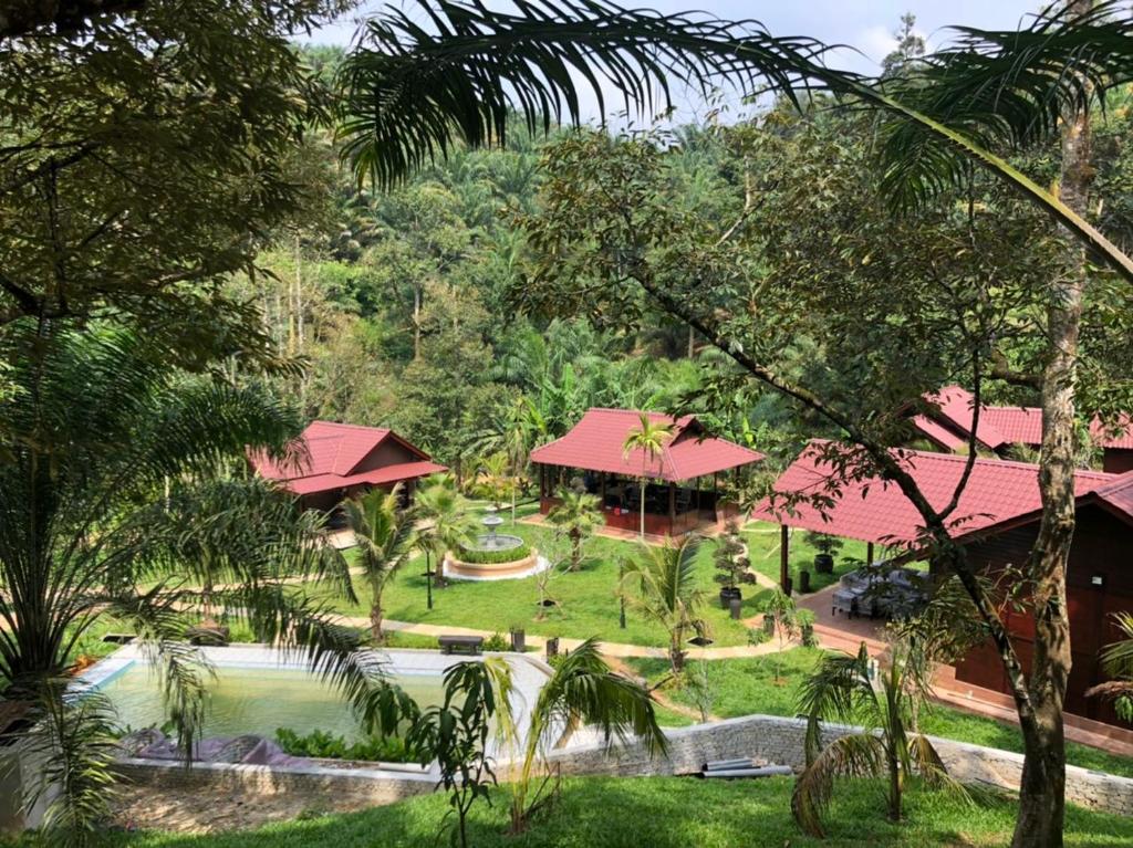 a view of a resort with a pool and trees at Kemuning Orchard Villaa in Kerling