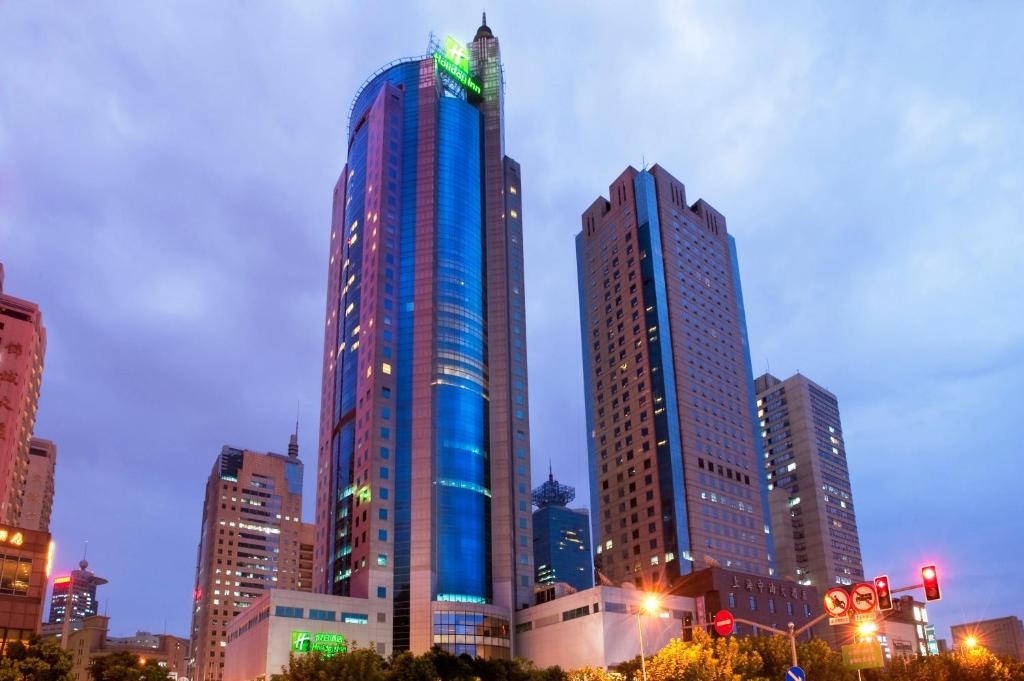 um edifício azul alto numa cidade à noite em Holiday Inn Shanghai Pudong, an IHG Hotel em Xangai