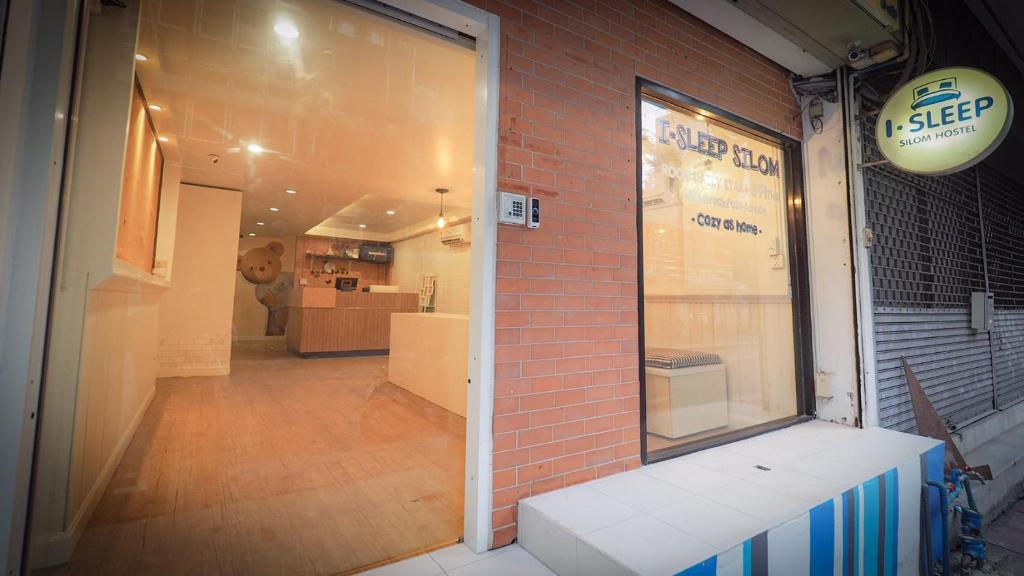 a store front with a brick wall and a window at I-Sleep Silom Hostel in Bangkok