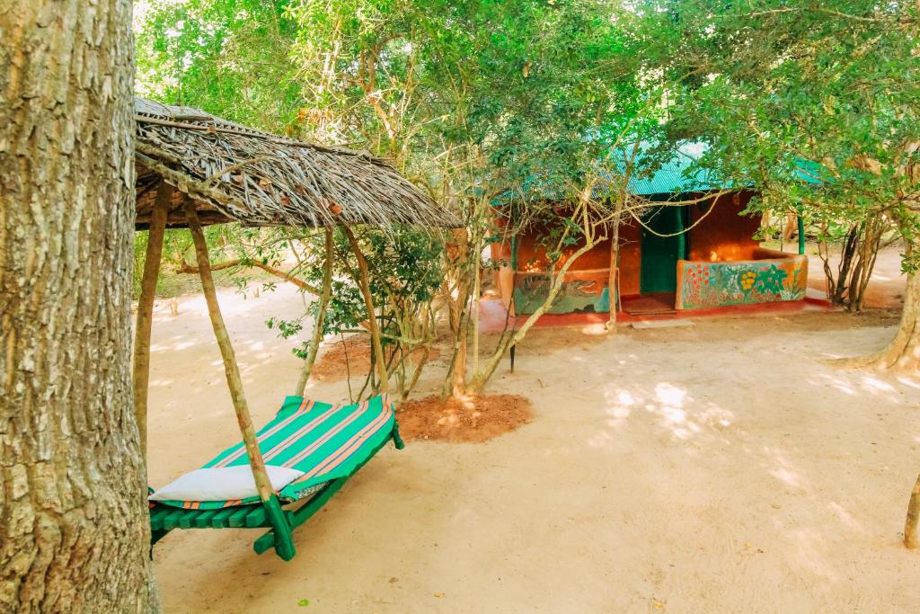 a hammock tied to a tree in front of a house at Yala Wild House in Yala