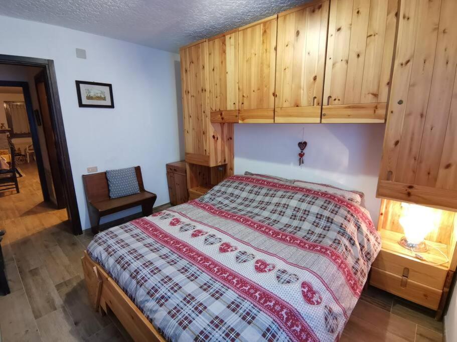 una camera con un letto e una parete in legno di Casa Cinque Funghi Folgarida a Folgarida
