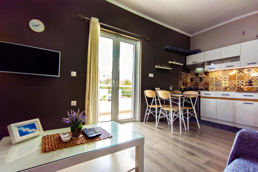 een keuken en een woonkamer met een tafel en stoelen bij Maria's modern studio 5min from beach in Souda