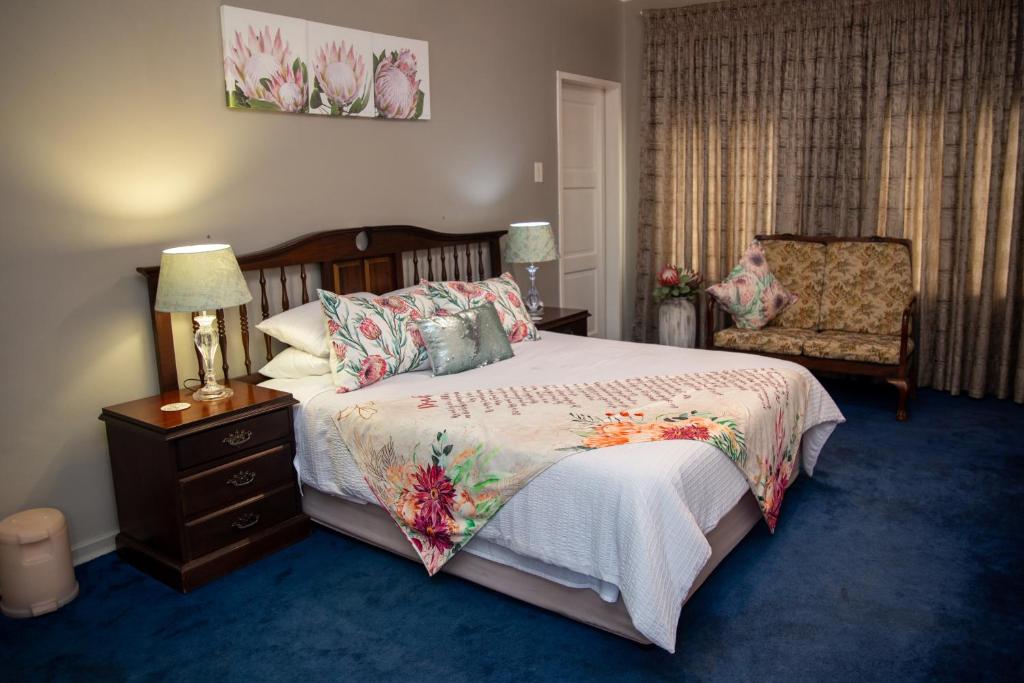 a bedroom with a large bed and a chair at Ailani Blue Room in Benoni