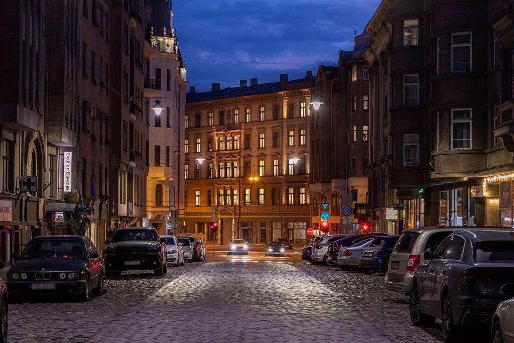 a city street at night with cars parked at HappyDog Lounge in Rīga
