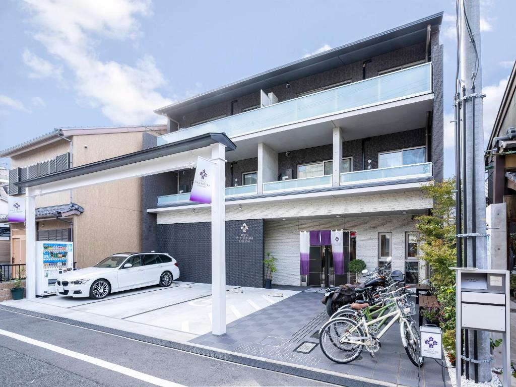 una macchina bianca parcheggiata di fronte a un edificio di Kyoto Four Sisters Residence a Kyoto