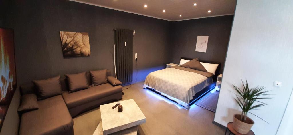 een woonkamer met een bed en een bank bij Luxus-Appartement II in Übach-Palenberg