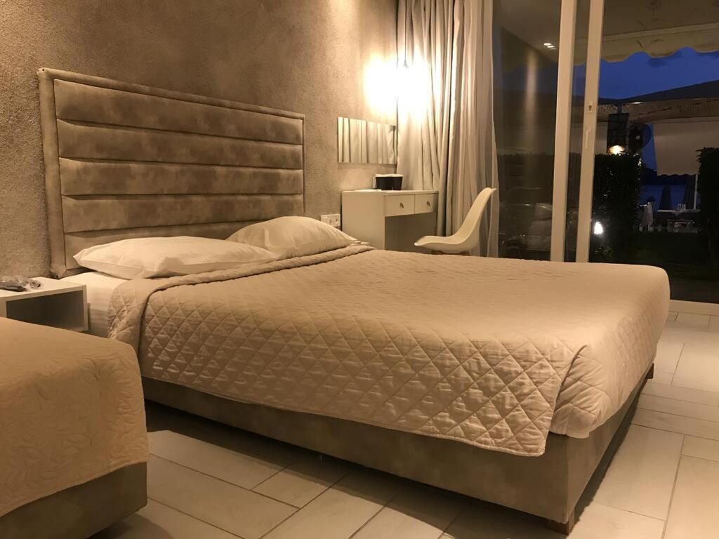 A bed or beds in a room at Porto Palio Beach Hotel