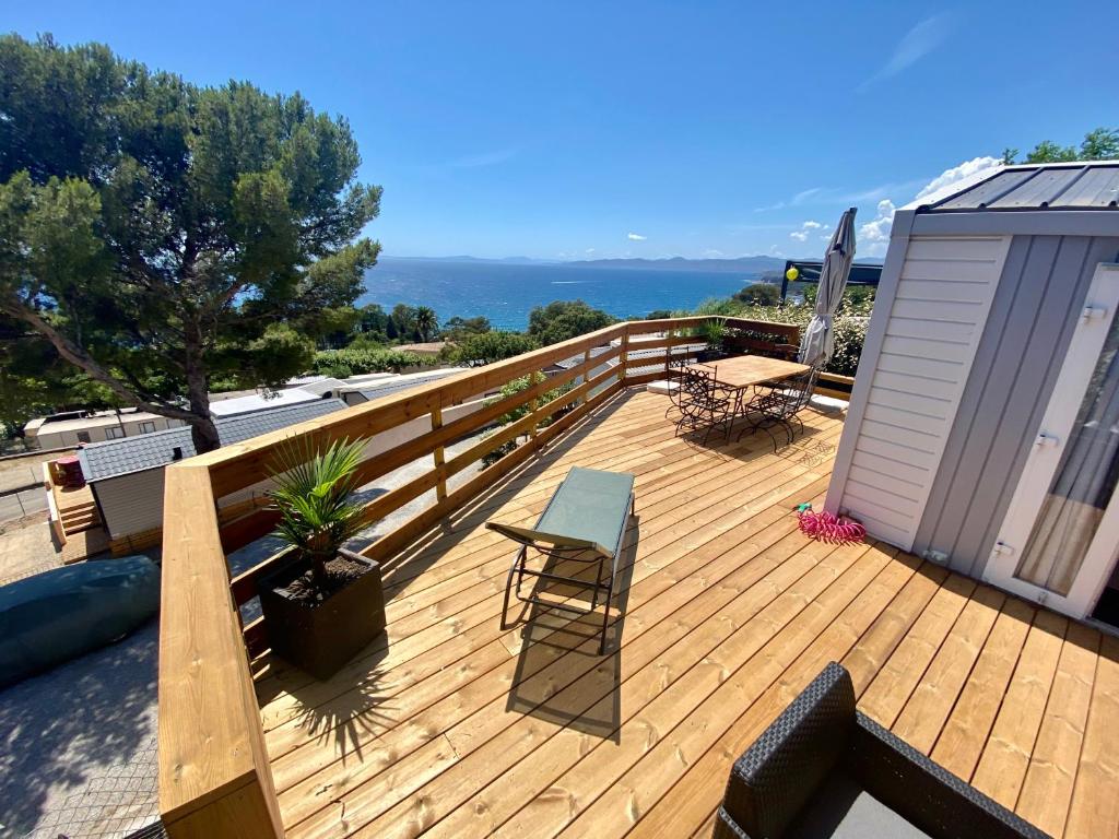 a wooden deck with a table and chairs on it at Mobilhome 6 places vue mer in Drammont