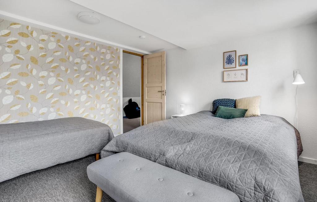 a bedroom with two beds and a wall at Skjoldbjerg Garnihotel in Vorbasse