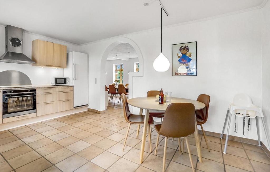 a kitchen and dining room with a table and chairs at Skjoldbjerg Garnihotel in Vorbasse