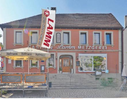 a building with a sign in front of it at Hotel Gasthof Metzgerei Lamm in Geiselwind