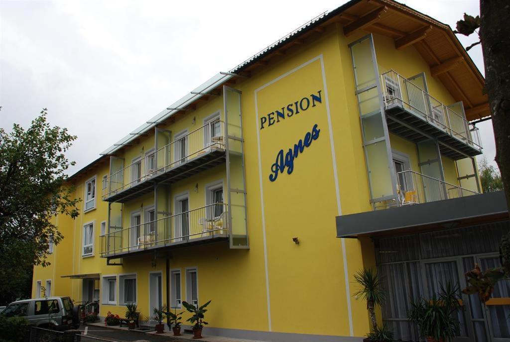 un edificio amarillo con un cartel en el costado en Pension Agnes en Sankt Kanzian