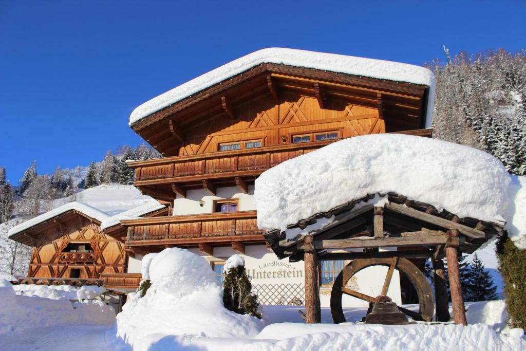 a log cabin with snow on the front of it at Residence Landhaus Rainer in Ridanna
