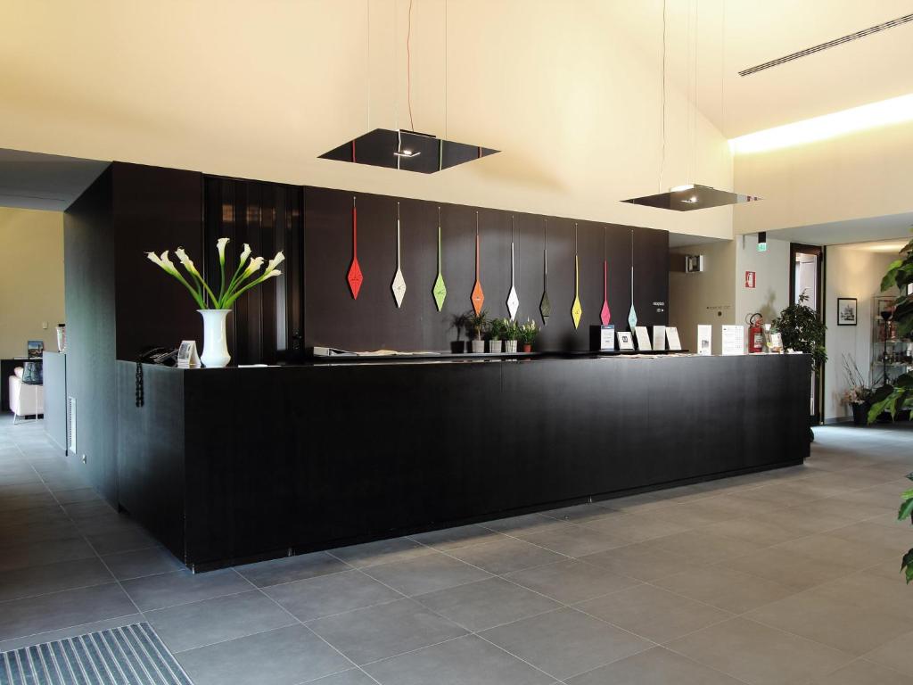 a lobby with a black counter with plants on it at Casalgrande Hotel in Salvaterra