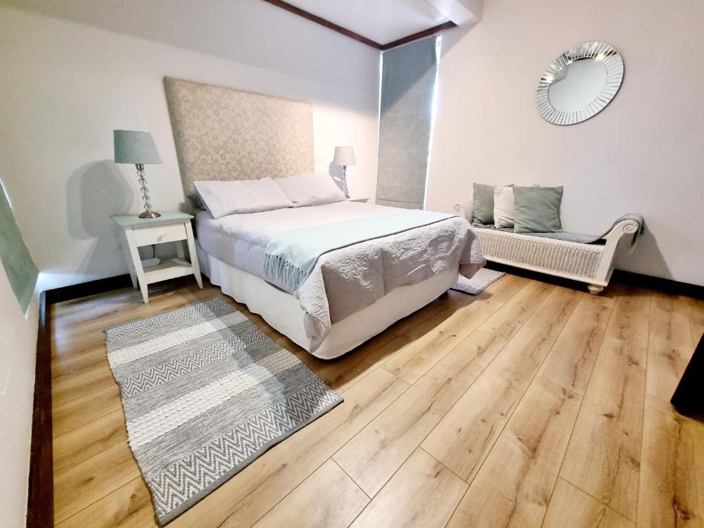a bedroom with a bed and wooden floors and a mirror at 15 Sovereign Sands in KwaDukuza