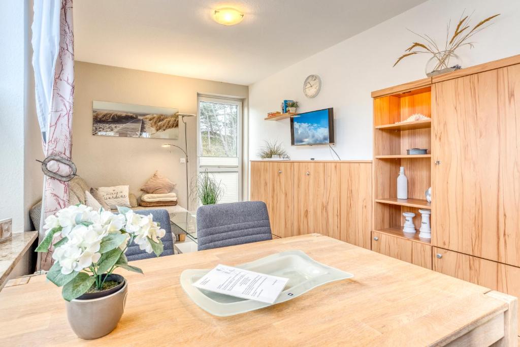 a living room with a table and a chair at Ferienhaus Waldrose in Norderney