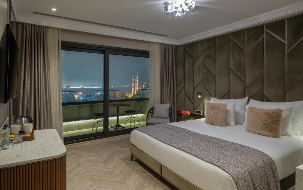 イスタンブールにあるホテル ネナのベッドと大きな窓が備わるホテルルームです。