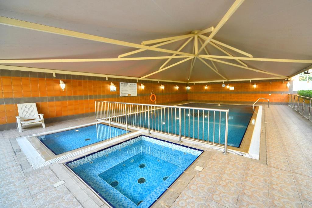 a large swimming pool in a building at Emirates Stars Hotel Apartments Dubai in Dubai
