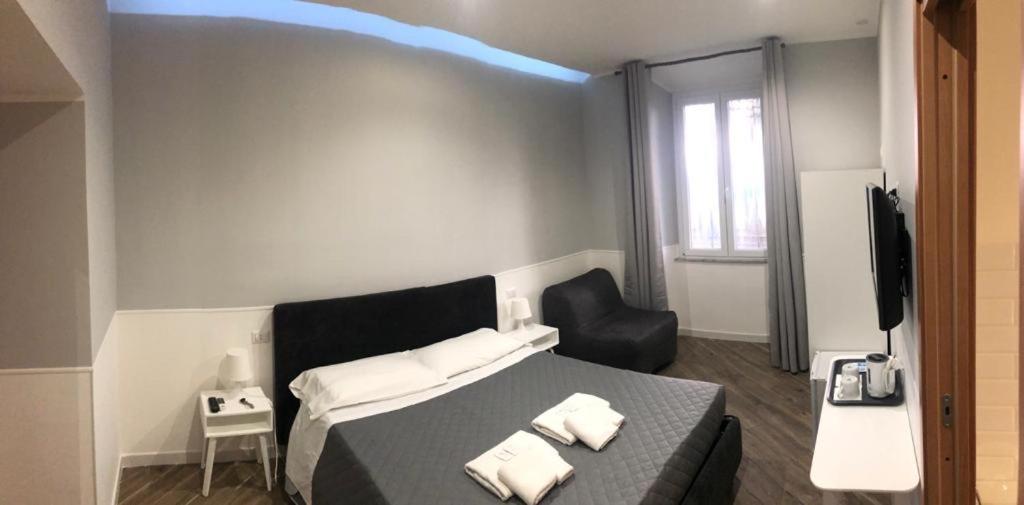 sypialnia z łóżkiem, krzesłem i telewizorem w obiekcie Rent Rooms Colosseum w Rzymie