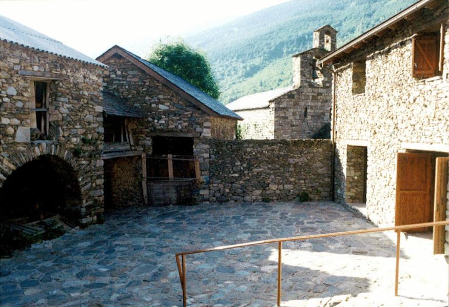 un gran patio en un edificio de piedra con una valla en Casa Farré, en Cardet