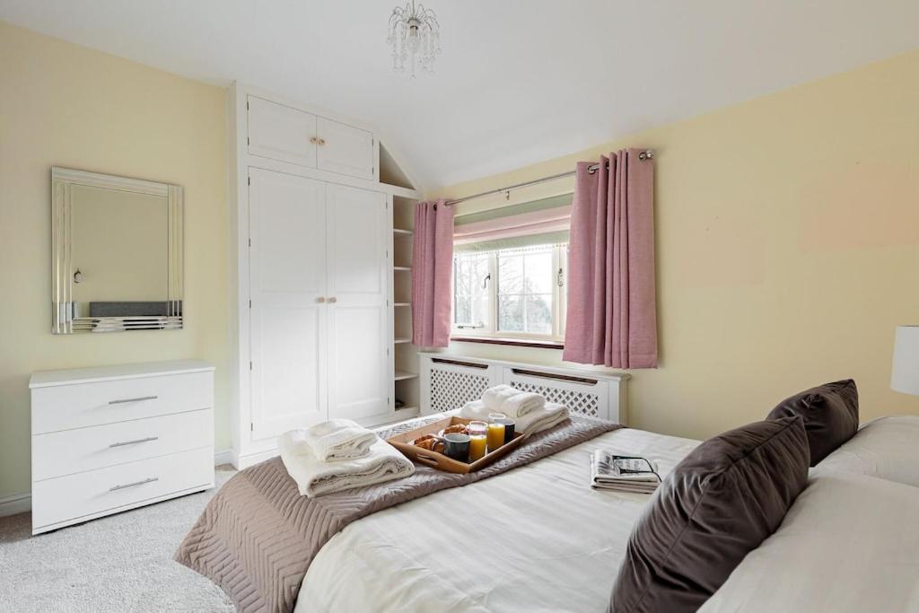 a bedroom with a bed with a tray of food on it at Dell View Cottage in Ashbourne