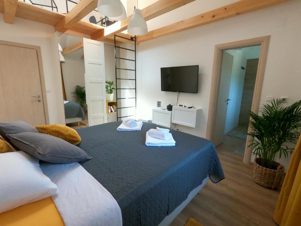 a bedroom with a bed with a tv on the wall at Gavan Room in Cres