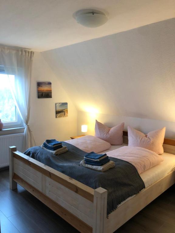 a bedroom with a large bed with towels on it at FeWo Vißer‘s Landblick in Krummhörn