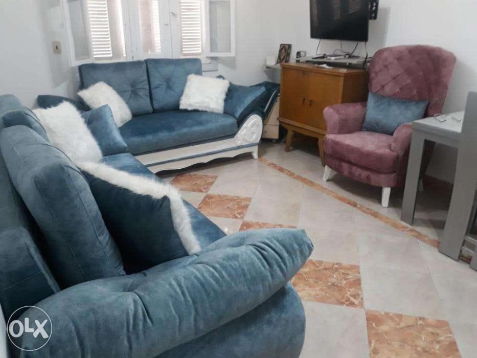 a living room with a blue couch and two chairs at Down Town apartment Nasr city in Cairo