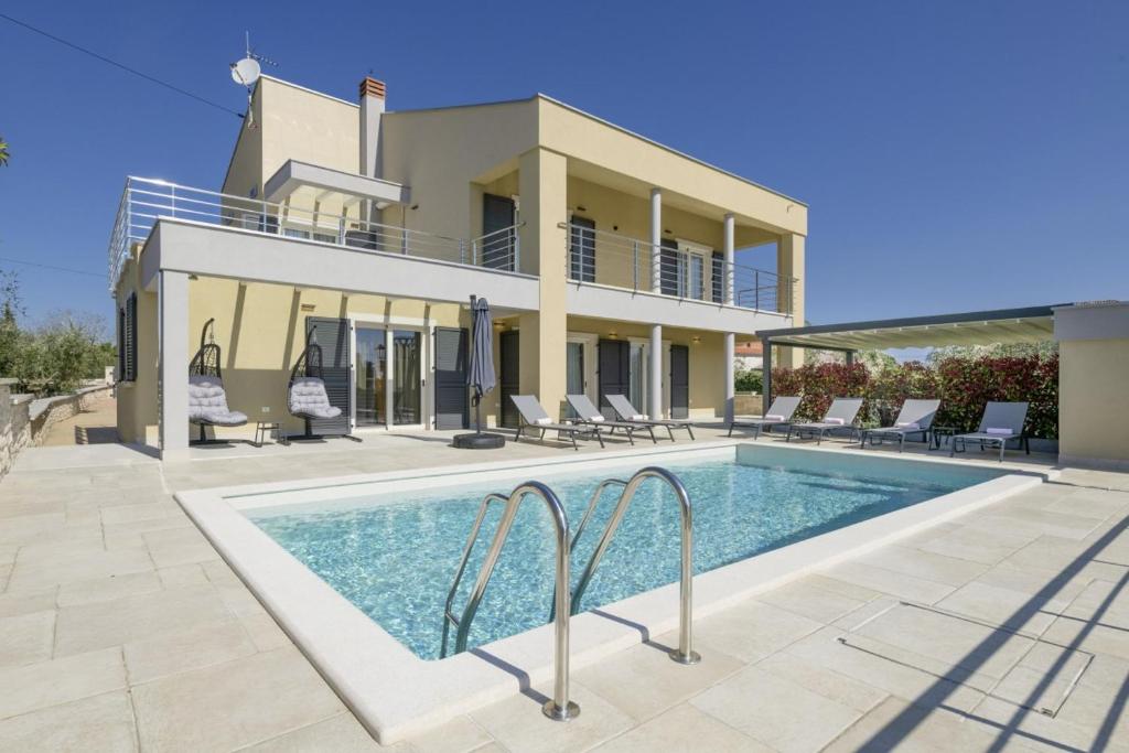 a villa with a swimming pool in front of a house at Villa Valentina in Krnica - Haus für 8-9 Personen in Krnica