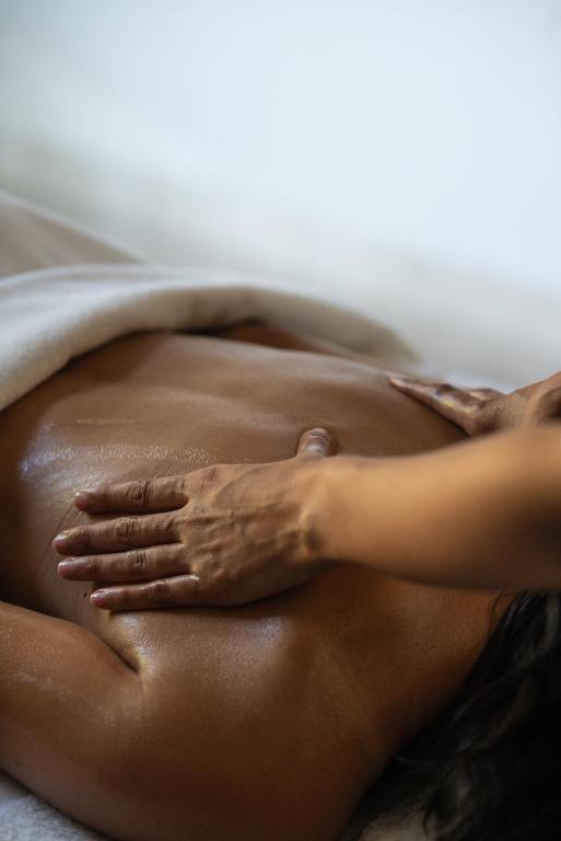 a woman laying on a bed with her hands on her stomach at Four Seasons Hotel Tunis in Gammarth