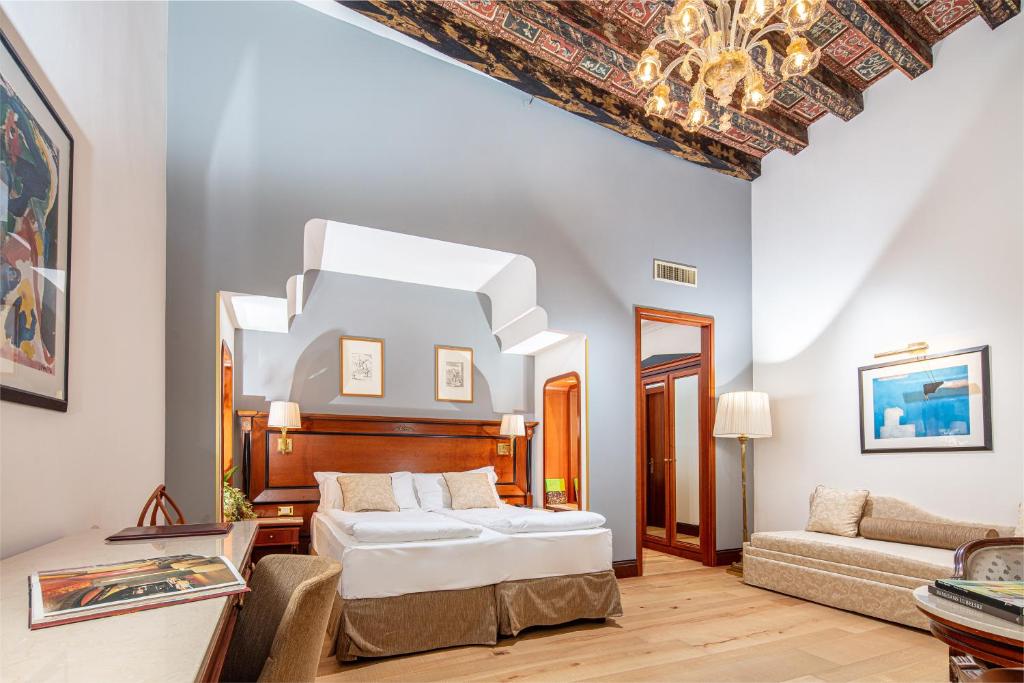 um quarto com uma cama e um sofá em All’Angelo Art Hotel em Veneza
