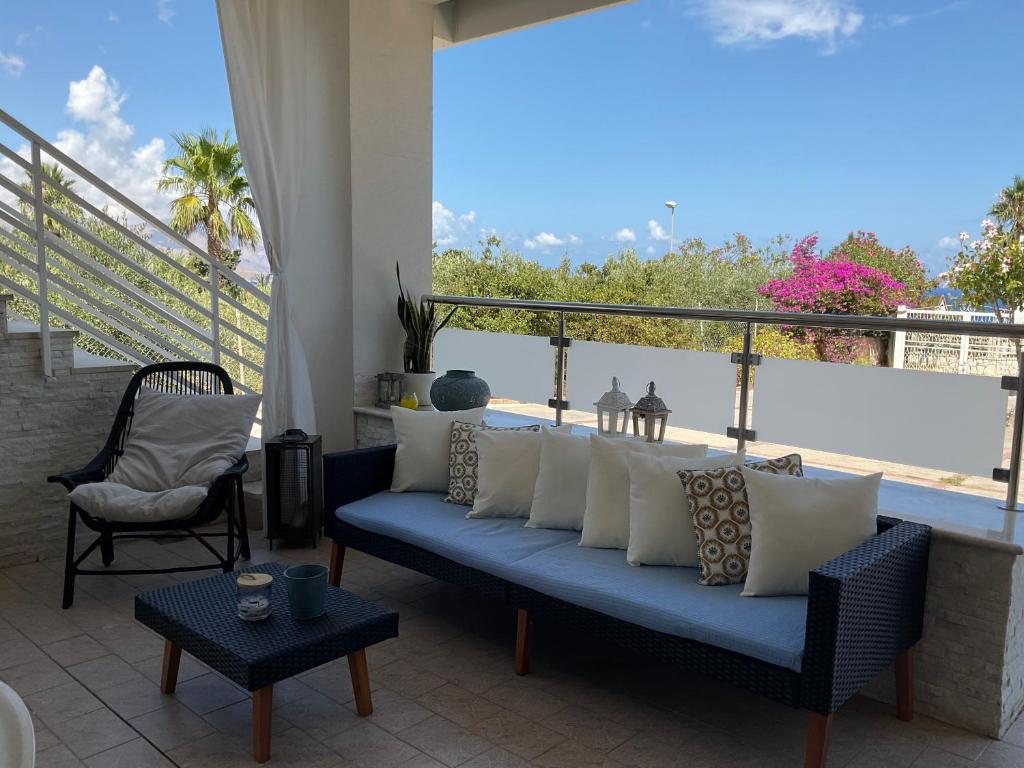 ein Wohnzimmer mit einem blauen Sofa und einem Balkon in der Unterkunft Casa novellagiovanni, relax mare bellezza in Alcamo