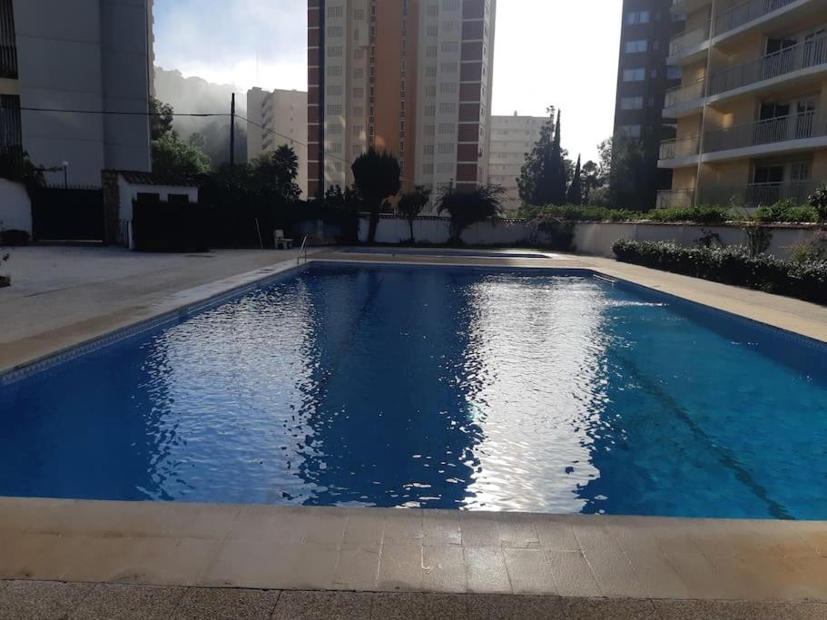 une piscine bleue au milieu d'un bâtiment dans l'établissement Beautiful residential apartment with pool, à Benidorm