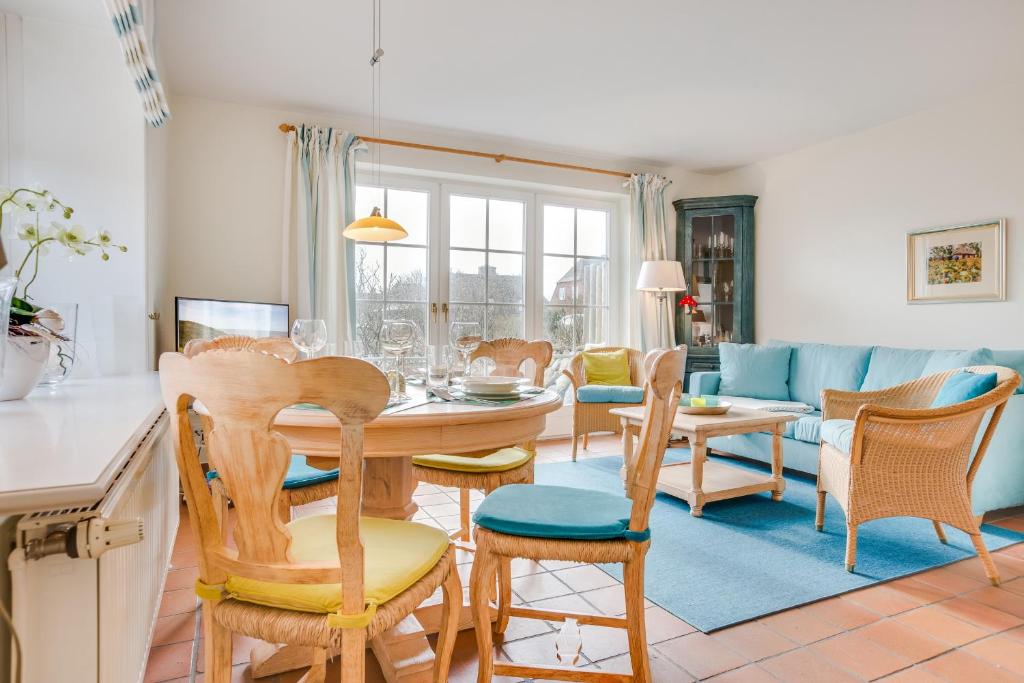 uma cozinha e sala de estar com mesa e cadeiras em Achter Duenem App 1 em Wenningstedt