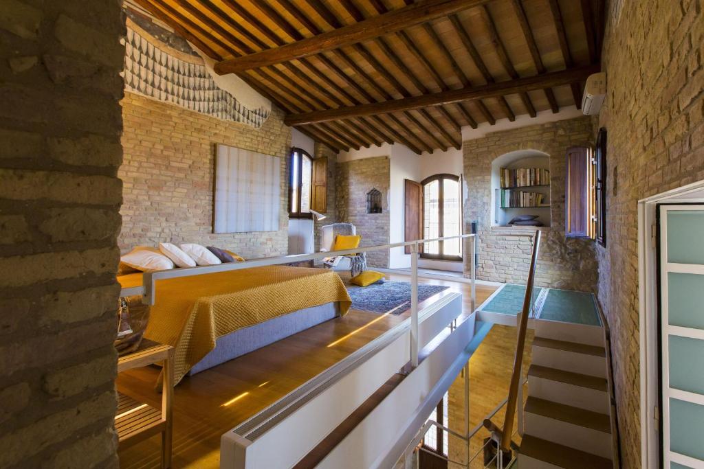 a room with a bed and a brick wall at Zafferano Rooftop Terrace Tower House in San Gimignano