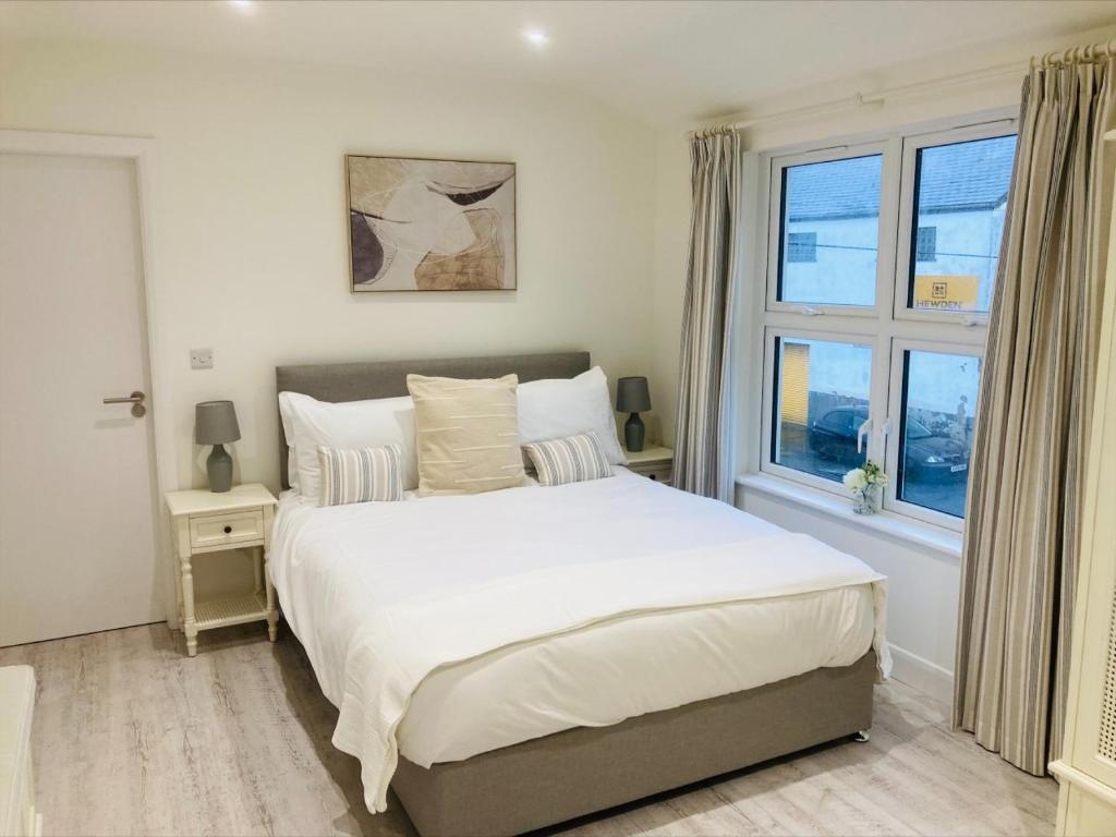 een slaapkamer met een groot bed en een raam bij The Bluebell Porthmadog in Porthmadog