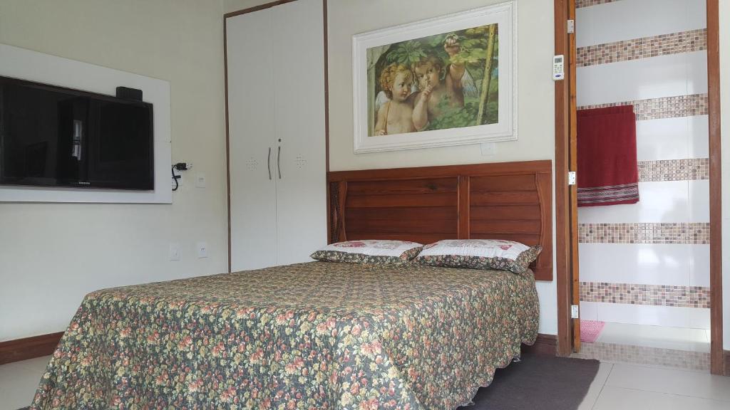 ein Schlafzimmer mit einem Bett und einem Fernseher darin in der Unterkunft Apartamento em Barra do Piraí in Barra do Piraí