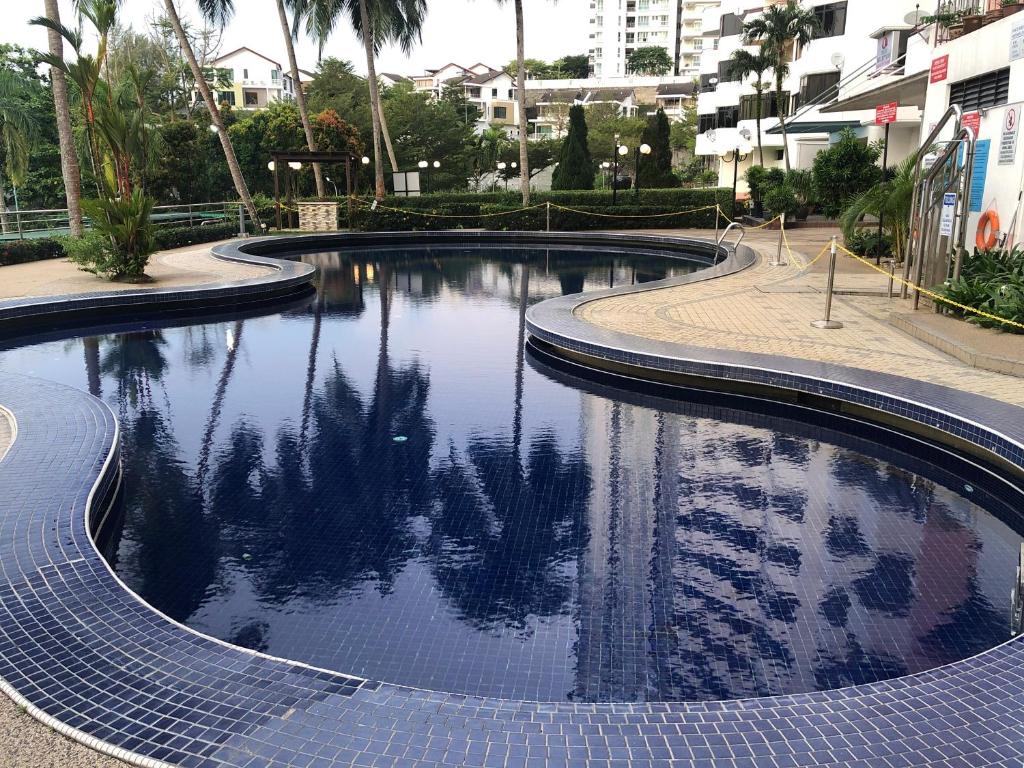 a swimming pool in a city with trees in the water at Beach Resort Home Stay Batu Ferringhi 02 in Batu Ferringhi