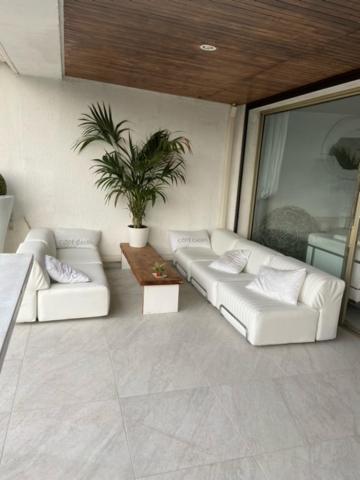 un salon avec des canapés blancs et une plante en pot dans l'établissement LA MAISON DE DOMS avec JACUZZI et vue mer, à Cassis