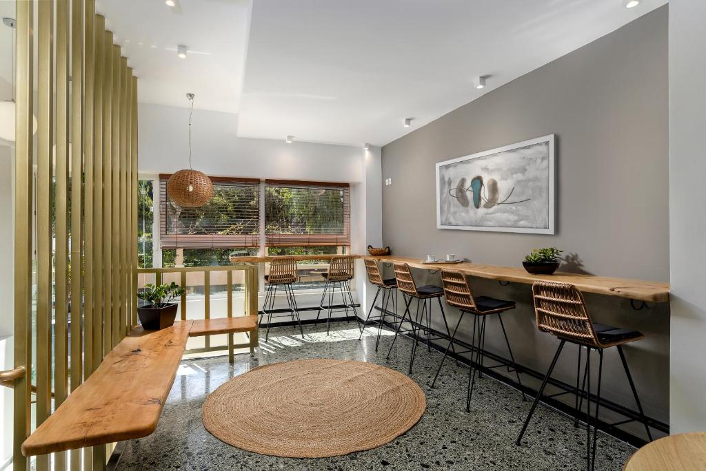 a kitchen with a bar with chairs and a table at Kipos Hotel in Rethymno