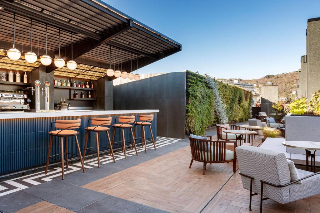 a patio with a bar and chairs and tables at Radisson Collection Bilbao in Bilbao