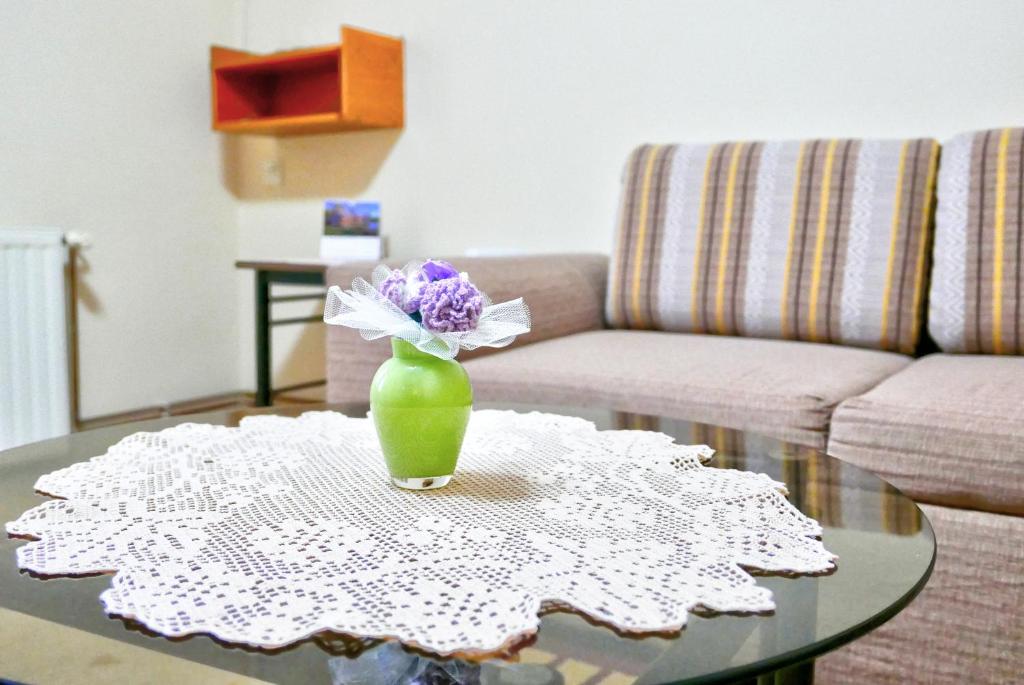 a vase with flowers on a table in a living room at Apartman Verona in Ilok