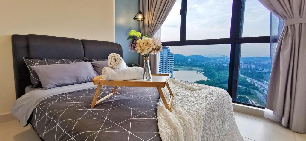 Un dormitorio con una cama y una mesa con flores. en Astetica Pool & Lake View High Floor 100mbps Wifi Netflix, en Seri Kembangan