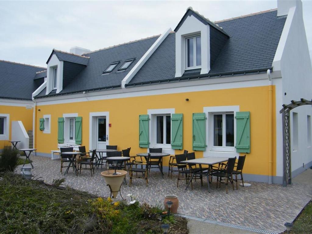 un bâtiment jaune et blanc avec des tables et des chaises dans l'établissement Parlevan, à Bangor