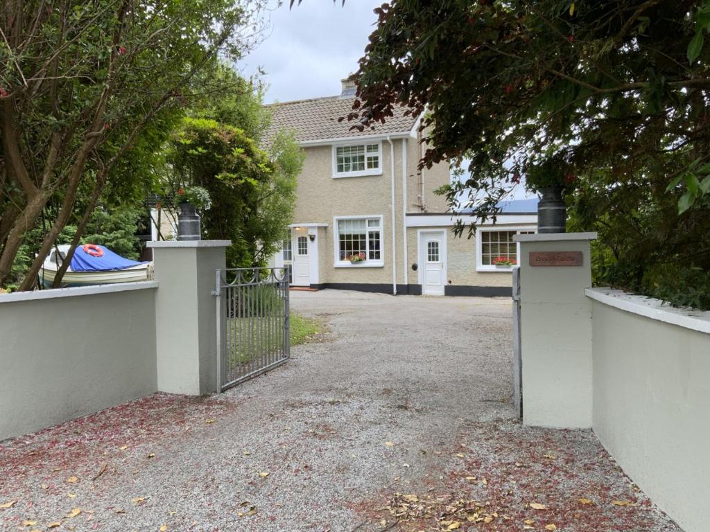 una casa con una puerta delante de una entrada en Broomfields en Greenane