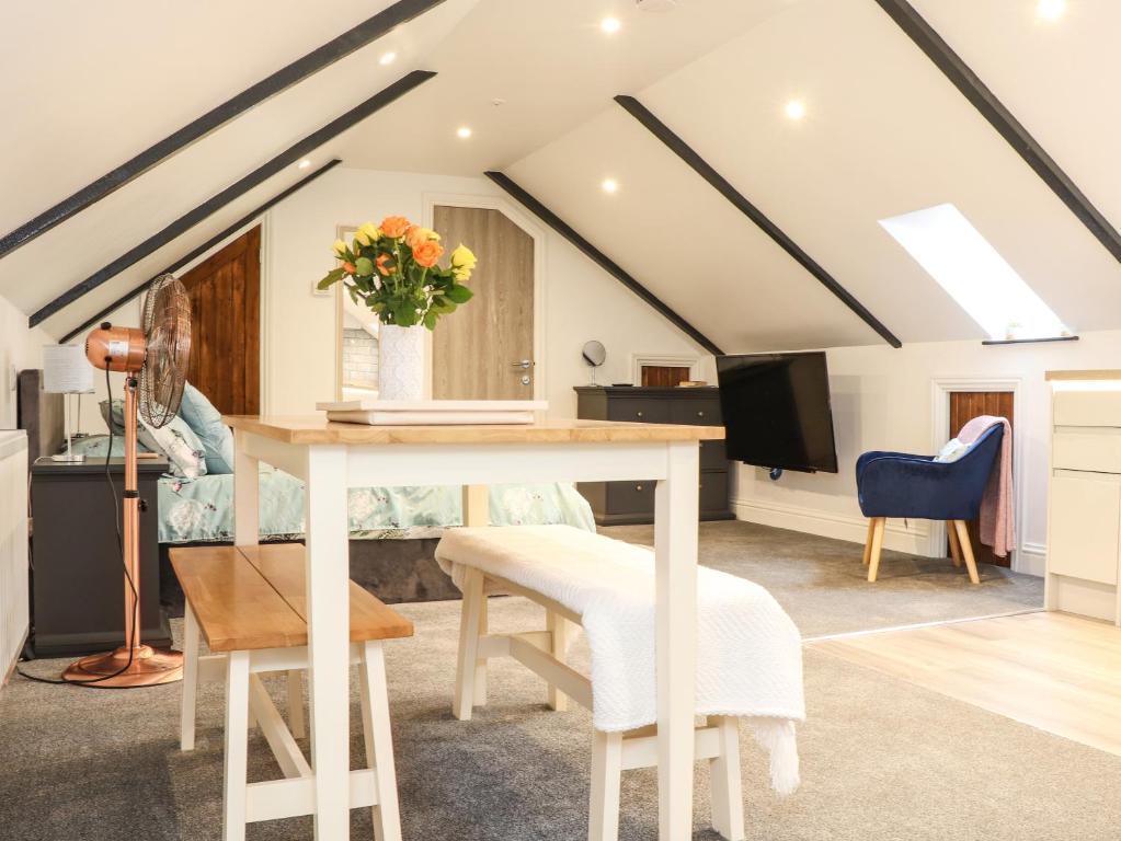 a living room with a table and a tv at Thomas Chambers in Camborne