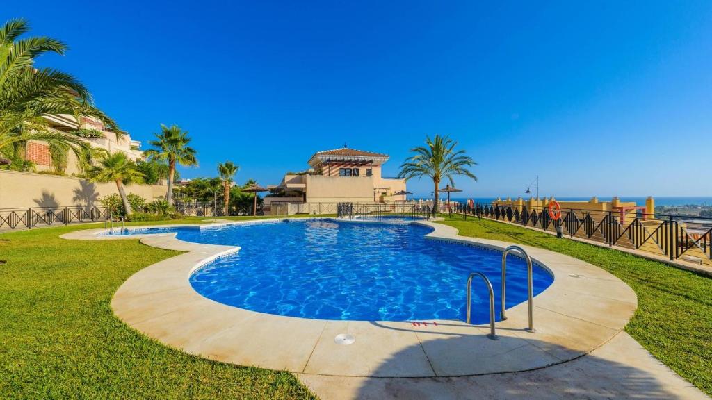 a swimming pool with palm trees and a building at Apartamento Brisa Almayate Alto by Ruralidays in Almayate Alto