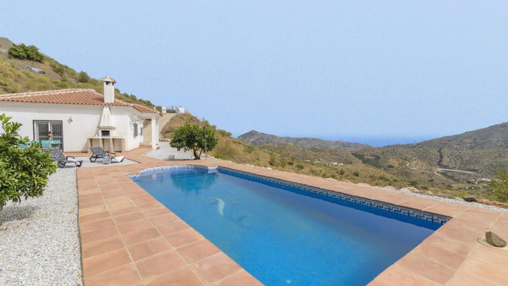 a villa with a swimming pool with a view of the ocean at Villa Las Reinas Arenas by Ruralidays in Arenas