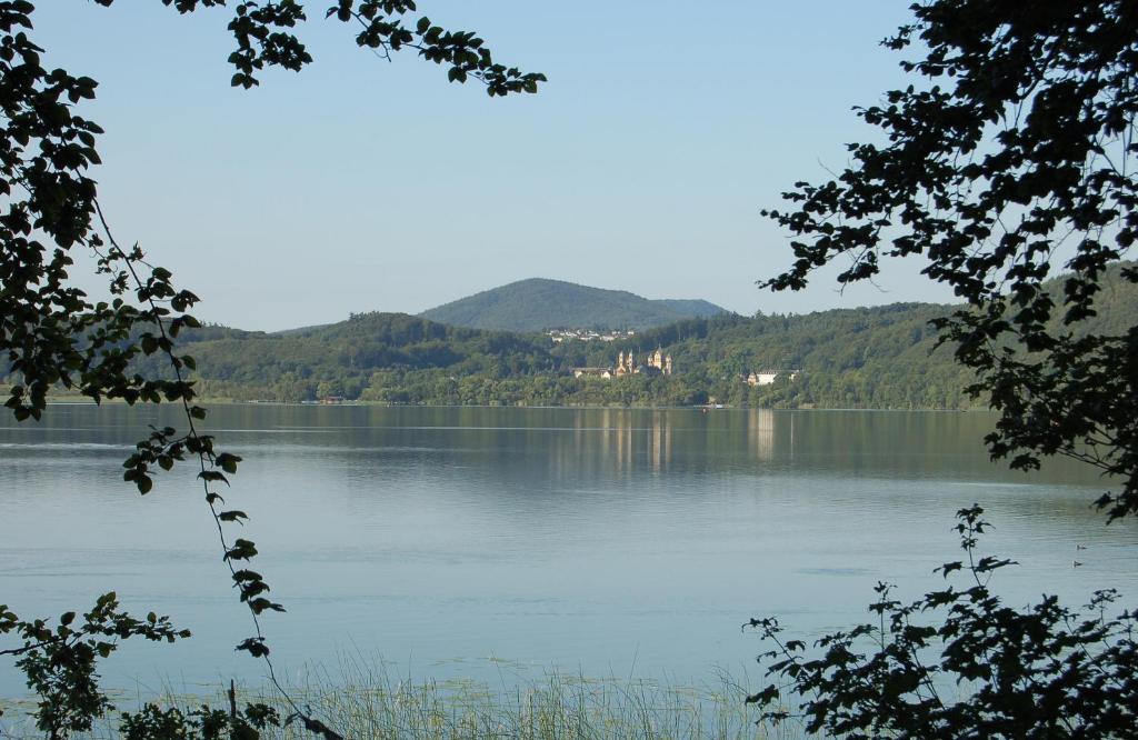 vistas a un lago con montañas en el fondo en Seehotel Maria Laach en Maria Laach